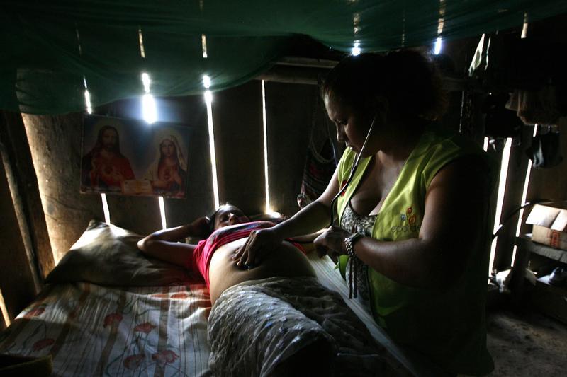 A doctor performs checks on a pregnant Ashuar Indian woman during a health campaign in Kapawi