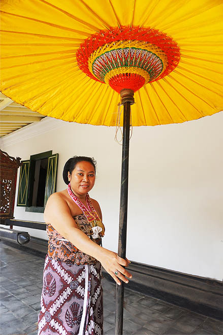 This woman holds the golden umbrella which is a symbol of royalty. When his mid-morning tea is delivered, the umbrellas are used to shade the procession as they make their way across the courtyard.© Jill Gocher 